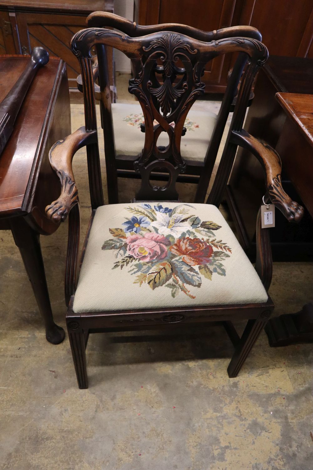 A pair of 19th century mahogany elbow chairs, scroll and leaf-carved and with lions paw armrests